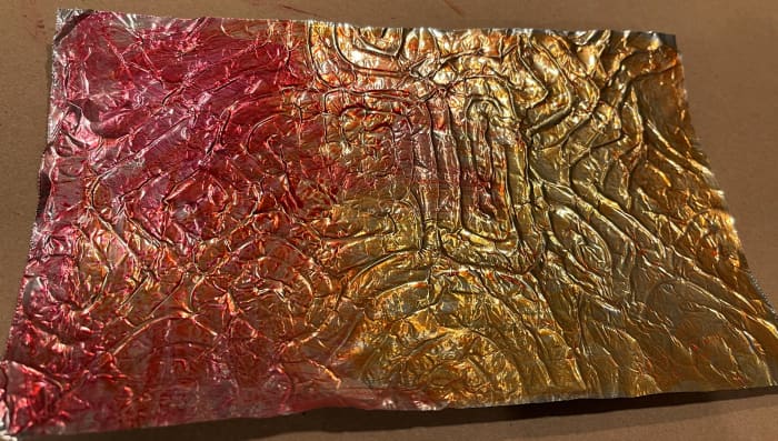 Using a wet flat brush, spread the paint on the foil. You can blend and transition between colors while the paint is still wet.