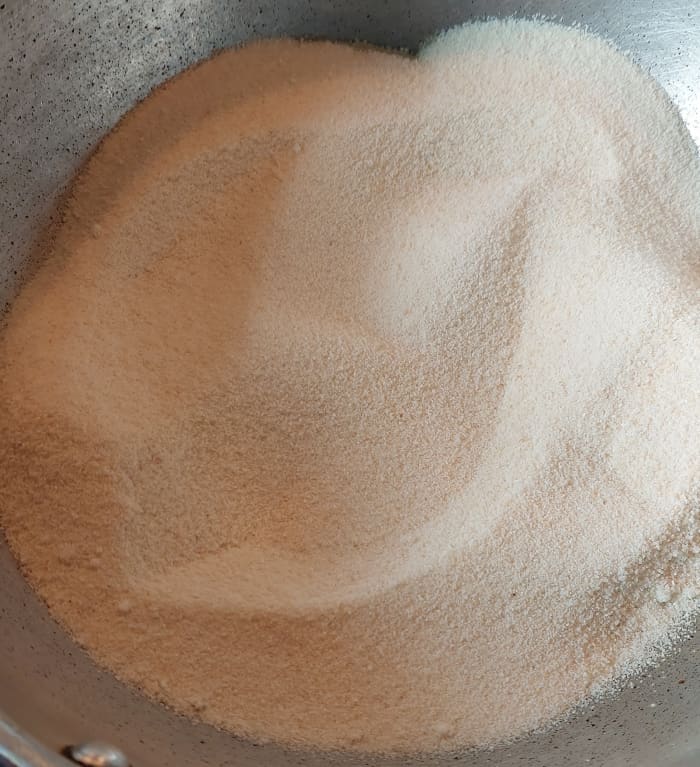 To the same ghee, add 2 cups of rava or suji. Fry till it changes to a light golden color and turns aromatic. Stir continuously for even roasting.