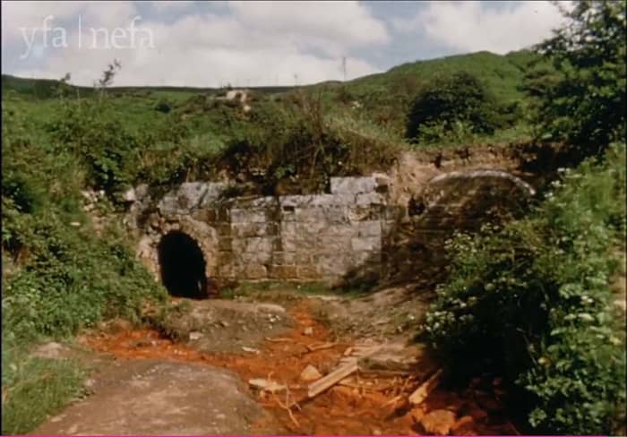 Afternath, 1964, 15 years after closure iron deposits ooze 'rusty water'. Some who were children at the time delighted in sloshing around in the 'rusty' water that escaped the closed workings. These have since been secured. There is now little to see