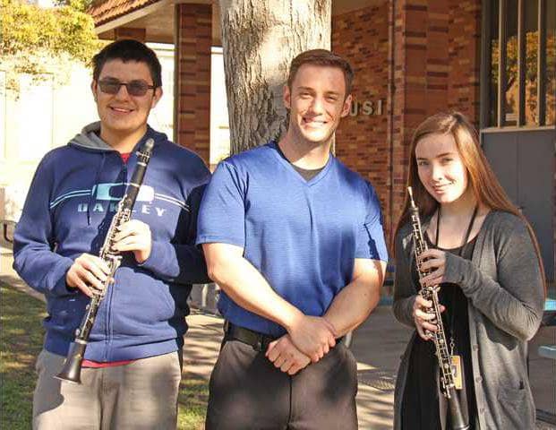 Junior and senior high band teacher Daniel Baudino was arrested for allegedly performing sexual acts with a minor child. (Baudino is standing in the center, between two former high school students.)