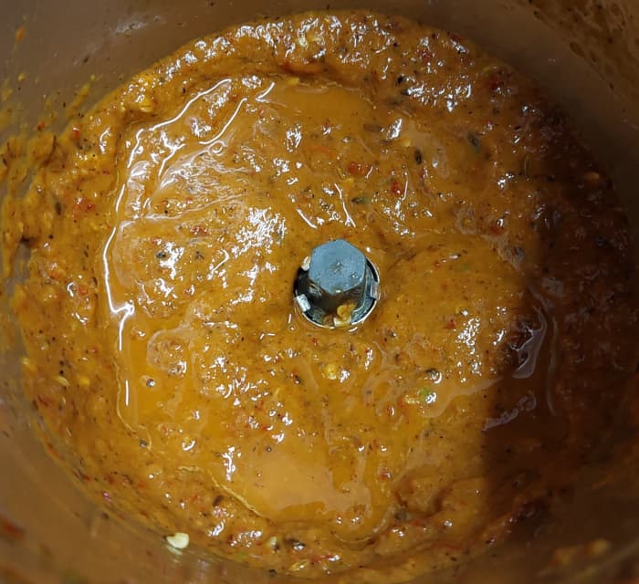 After cooling down, transfer it into a mixer jar. Add 1/2 cup of water and grind to a smooth paste (add more water if required). Set aside.