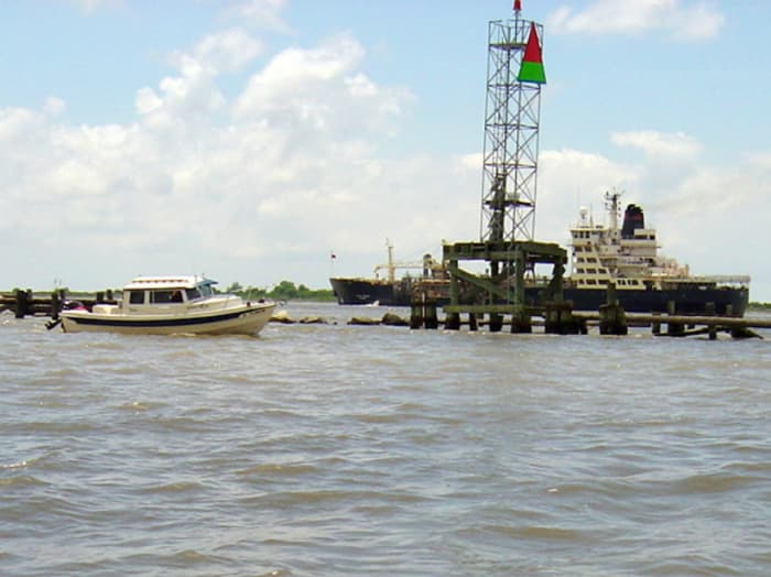 "Bixby's Cub" turns for a photo op at the bottom mile marker at Head of Passes, the official end of the Mississippi River. A tanker is going the opposite direction.