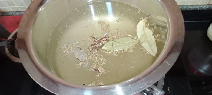 Heat some water in another vessel to cook rice. Add cumin seeds, salt, cinnamon, cloves, bay leaf & black pepper to the water.