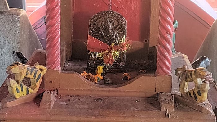 Durga idol on a wooden pedestal in the ante-chamber; close view. Note the wooden tigers; Dirgheshwari