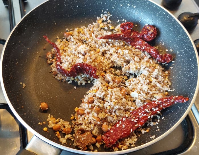 add 2-3 byadagi red chilies (non spicy), 1 teaspoon of tamarind, fry till coconut turns brown. Switch off the flame and let it cool down.
