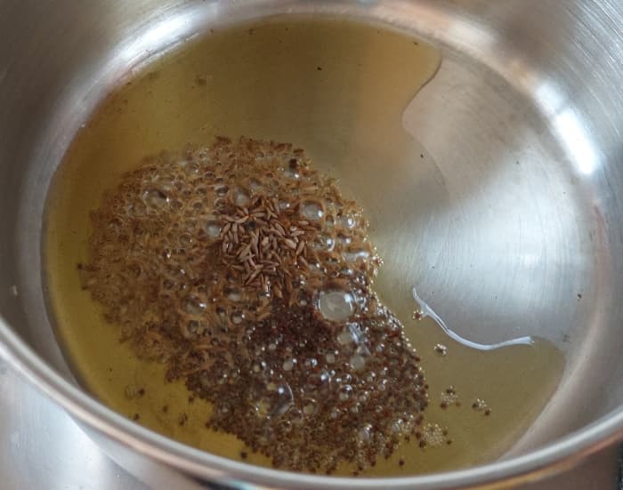 In a pan, heat 1 tablespoon of ghee (or oil), splutter 1/2 teaspoon of mustard seeds and 1 teaspoon of cumin seeds.