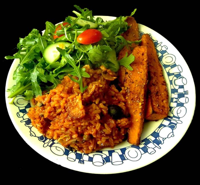 Brown rice risotto with mushrooms, onion, peas and black olives, and nuggets of sausage, sweet potato wedges and green salad