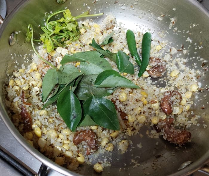 Add 1–2 green chilies (or to taste), 1–2 sprigs of curry leaves and 1–2 tablespoons of coriander leaves.