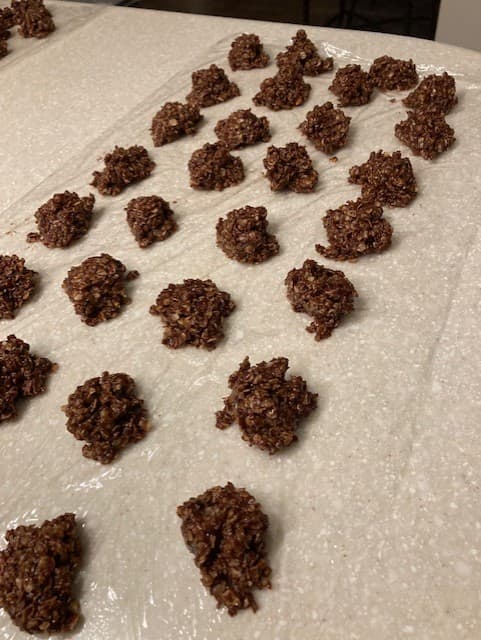 You can drop the cookies onto plastic wrap if wax paper isn't available, but wax paper is easier to work with.