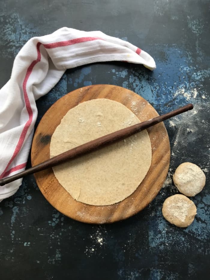 Roti dough, wheat flour with salt and oil (optional) added to it, is kneaded with soft consistency and then, made into little balls for rolling it uniformly round with the help of a roller ....