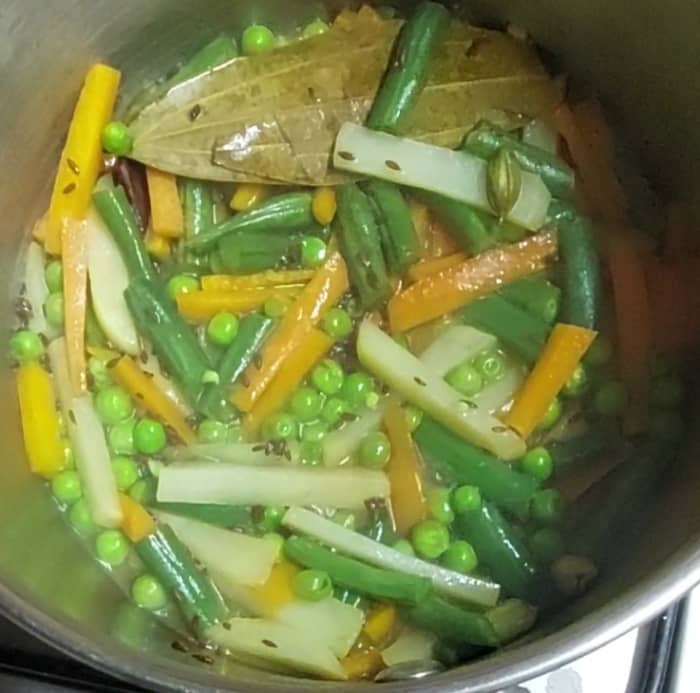 Add 1/2 cup of water and salt to taste, close the lid and cook over low flame till vegetables are half-cooked.