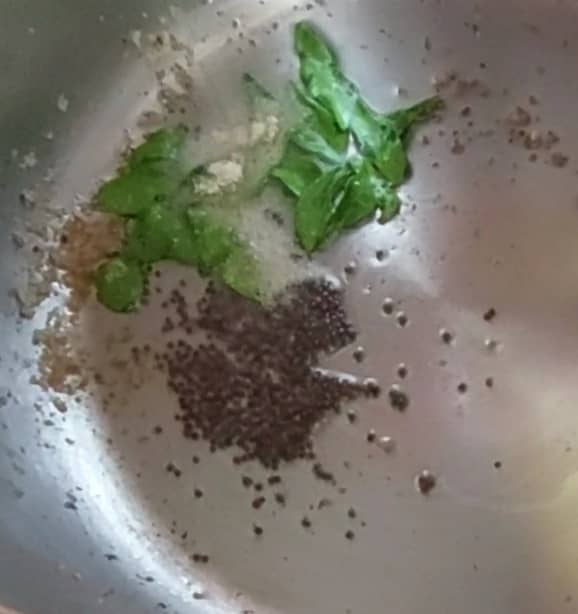 In a pan or vessel, heat 1-2 teaspoons oil, splutter 1/2 teaspoon mustard seeds, add 1-2 sprigs curry leaves and 1/4 teaspoon hing. Fry for a few seconds.