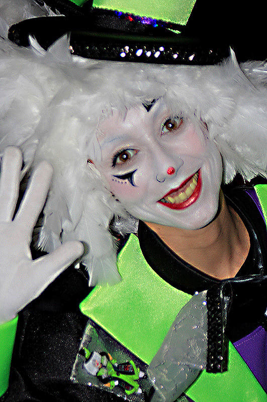 A painted face, a friendly smile and a wave which says "Welcome to the Santa Cruz Carnival in Tenerife!"