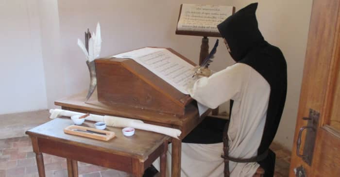 This image shows a monk scribe, quill in hand, in a typical work station. Occasionally scribes worked in solitude but were still part of a larger team.