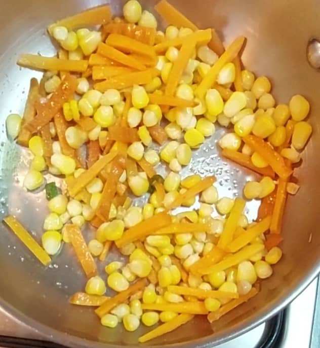 Add 1/4 cup chopped carrots and fry for one minute. Add cooked corn and salt to taste. Mix well. Close the lid and cook for 2 minutes.