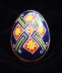 Again the eight-pointed star is present in this egg along with the pine branches. Each egg usually has the main design repeated on two sides, with an intricate border separating them.