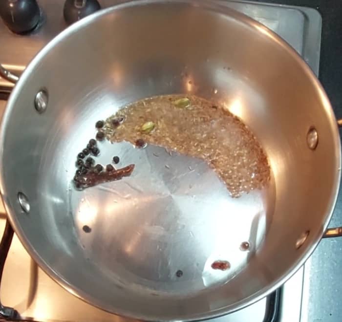 In a pan heat, 1 tablespoon oil or ghee, add 2-inch-long cinnamon stick, 2-3 cardamom pods, 2-3 cloves,1 teaspoon cumin seeds, 1/2 teaspoon peppercorns. Let the cumin seeds splutter.