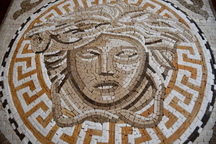 This is the mosaic I own. It's of the Versace logo. It is very detailed: there are hundreds of tiny stones. The stones have been cut and colored to help create dimension.