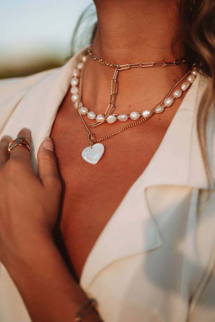 Gemini jewelry is a fusion of different pieces all worn at once. A heart-shaped necklace with a strand of pearls gives off a spring vibe.