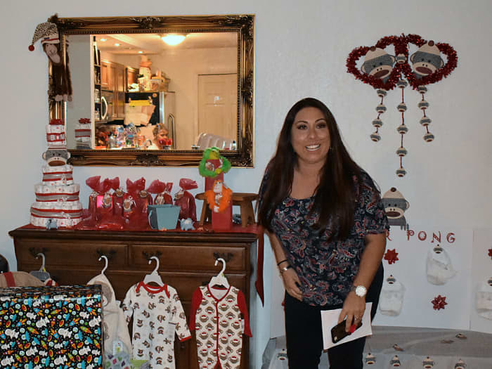 My cousin getting ready to choose her prize. In the background you can see the diaper cake on the table with the game prizes and the diaper pong game along with some other sock monkey decorations.