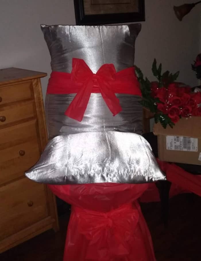 I used one of my bar stools from home for her chair, because it was taller than the rest. I purchased 2 satin pillow cases at the dollar store and put pillows in them and rapped the bottom with a red table cloth. Below is a closer look at the setup.