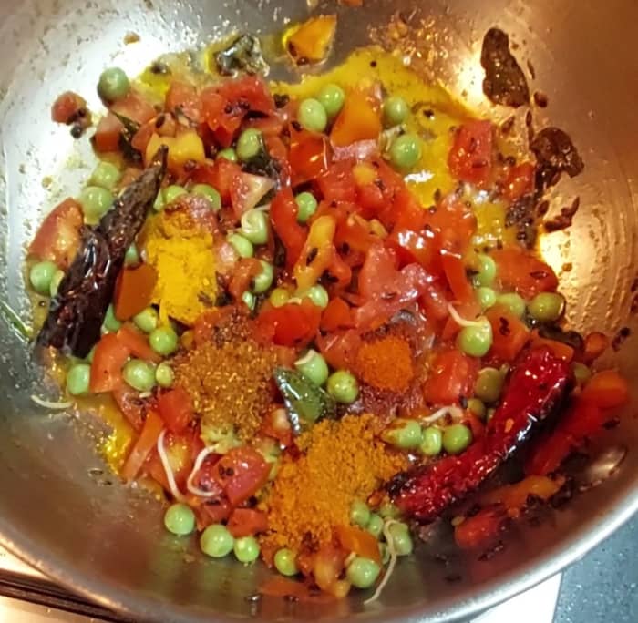 Add 1/2 teaspoon turmeric powder, 1 teaspoon red chili powder, 1/2 teaspoon garam masala powder and optional 1 teaspoon vangibath powder. Mix well.