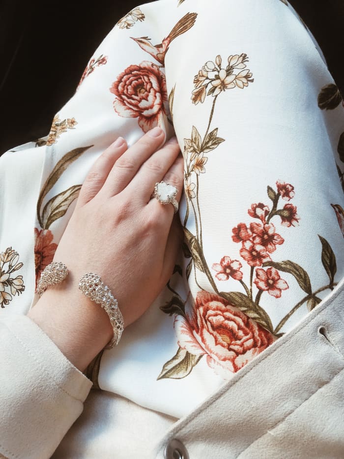 Libra should play with different styles for their jewelry. A mix of big, elegant, childish, and colorful projects a Libra vibe. The big silver bracelet and heart-shaped ring express sweetness and innocence. The floral pants are also on trend.