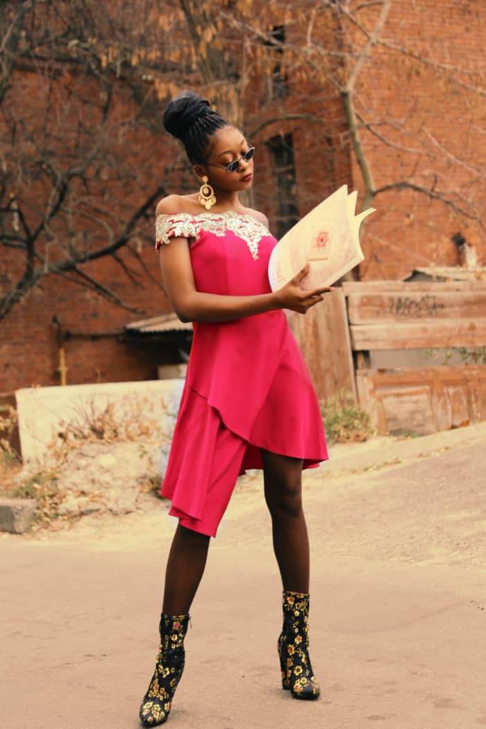 Aries fashion: flaunting a red dress that's asymmetrical and not form-fitting, big gold earrings, and killer boots.