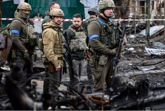 Volodymyr Zelensky (C) walks through the town of Bucha, northwest of Kyiv, the site of Russia's massacre of civilian residents