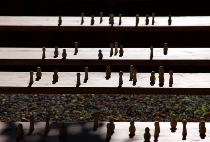 A set of wooden figurines on a ladder that represent the social ladder. It is said that in life those that come from the higher economic classes have the upper hand on those less fortunate,