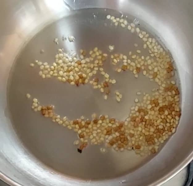 In a pan, heat 1 tablespoon oil. Add 1 teaspoon urad dal and 1/2 teaspoon methi or fenugreek seeds. Fry till dal turns golden brown.