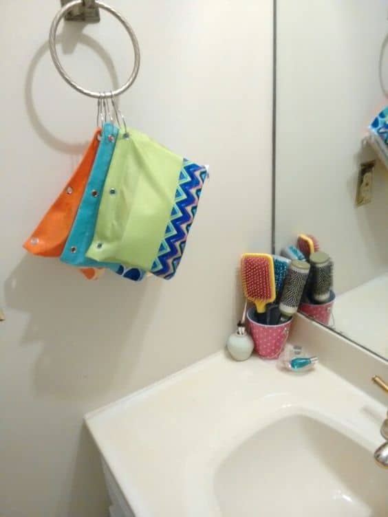 Dollar Tree organizing—hanging makeup bags (pencil cases and shower curtain rings) and metal tin bucket for brushes