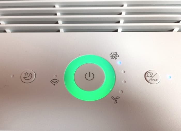 View of control panel displaying power switch, day/night button, wi-fi indicator, and UV-C/negative ion button. The ring color denotes the purity of the surrounding air