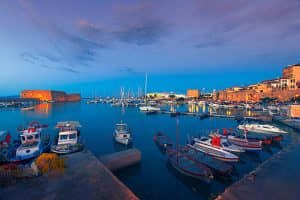 "Fishing boats and sailboat line the dockside in the beautifully set Greek nautical village. Old fortress in Heraklion, Crete - Greece, Venetian Fortress."