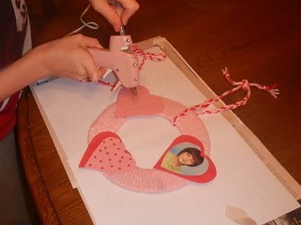 Glue the decorations in a pleasing pattern on the wreath.