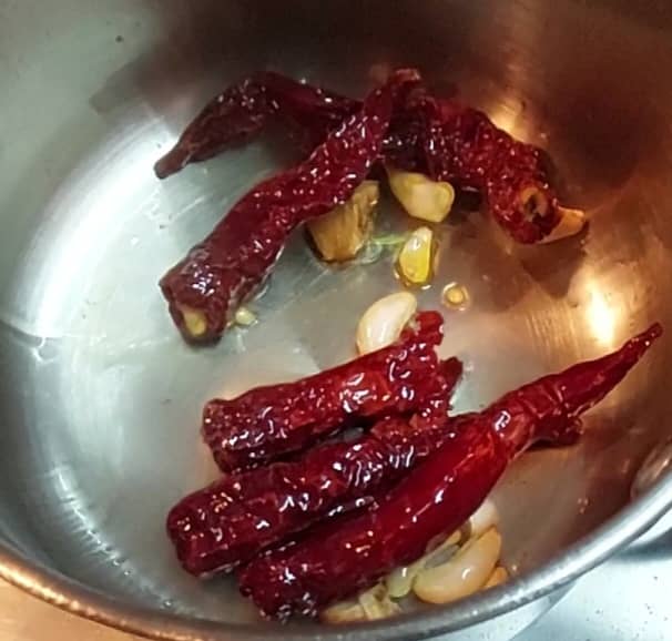 Add soaked red chilies (drain water) and saute for 1 minute or till the chilies become bloated. Switch off the flame.