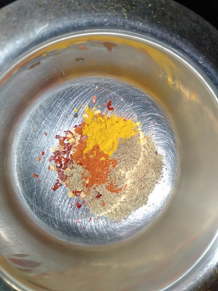 Combine all of the dried spices in a bowl (red chilli flakes, red chilli powder, coriander powder, turmeric powder and garam masala powder).