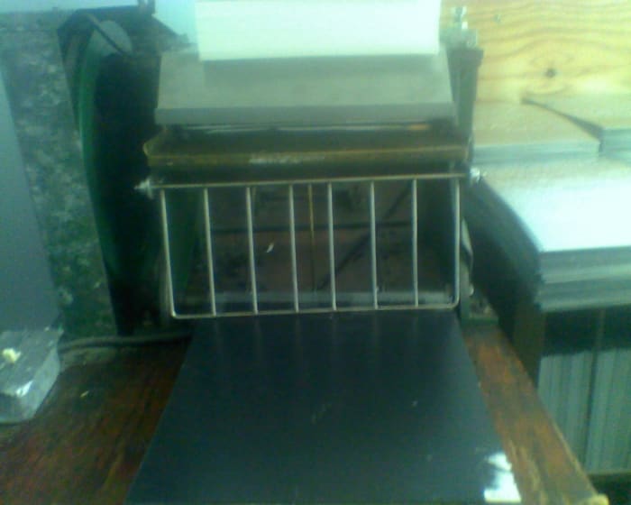 Proof Press, which rolls the embossed plate with a page of paper, to create a document proof for a braille proofreader to check.