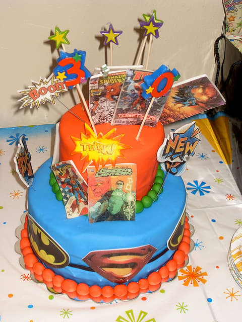 Super hero cake featuring batman, Superman, green latern etc. Highlights include the comic book decorations and the cake toppers