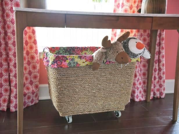 Make a mobile toy box out of a container. Add jute cord, metal casters and a decorative cloth lining to a plain plastic storage bin to give it new life.