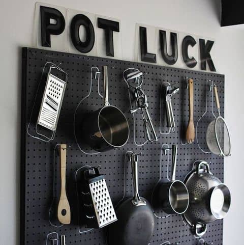 A black pegboard transforms a bare, blank wall into a stylish room. Hang your pots and pans on hooks and draw a chalk circle around them so you don't forget where they belong.