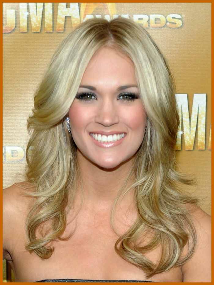 Carrie Underwood with light ash blonde hair, parted in the center, layered, and slightly flipped. Celebrities with Light Ash Blonde Hair Color.