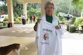 Macrine showing off the newly purchased Mission T-shirts in front of the  CDM Conference Hall