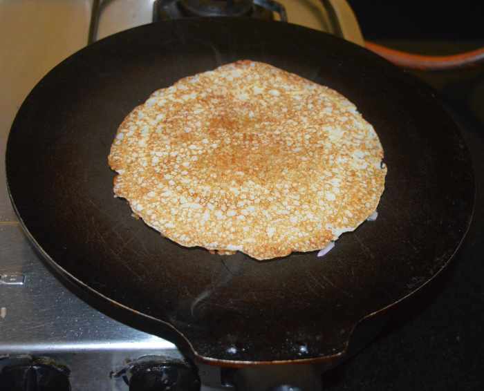 Press it a little with a spatula. Add half a teaspoon of oil on the top. Cook on medium heat until the bottom becomes golden brown. Flip it. Add half a teaspoon of oil on the top. Let the other side also become golden brown.