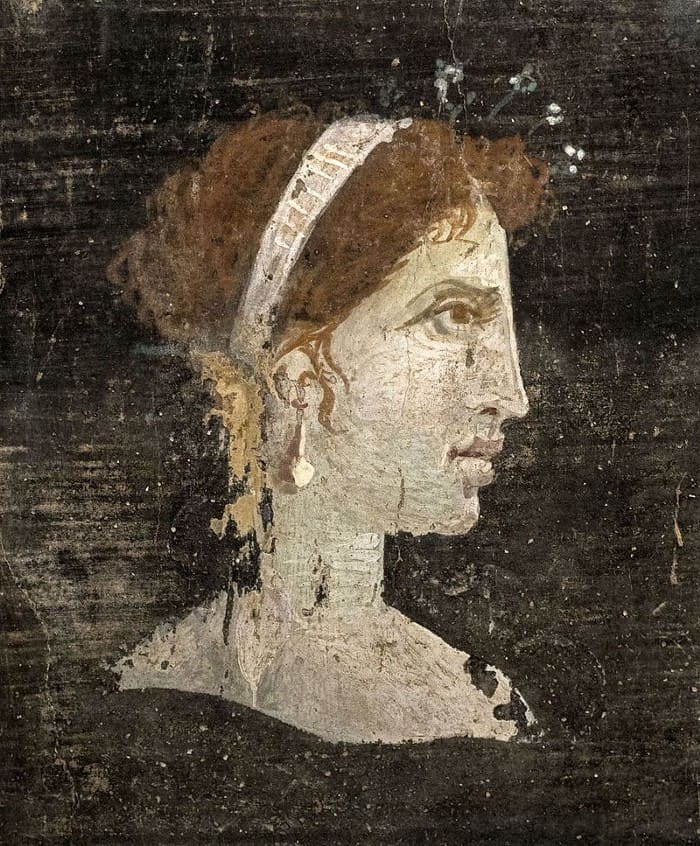 Most likely a posthumous painted portrait of Cleopatra VII of Ptolemaic Egypt with red hair and her distinct facial features, wearing a royal diadem and pearl-studded hairpins, from Roman Herculaneum, Italy, 1st century AD