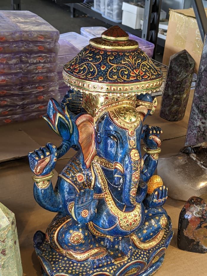 This is a ceramic elephant at a booth selling traditional Indian art fabrics