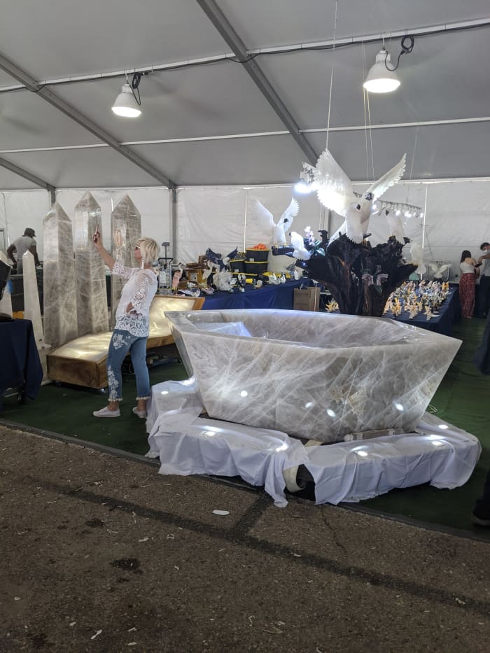 My wife taking a selfie in front of a multi ton granite or marble bathtub for sale at the Tucson Gem and Mineral Show