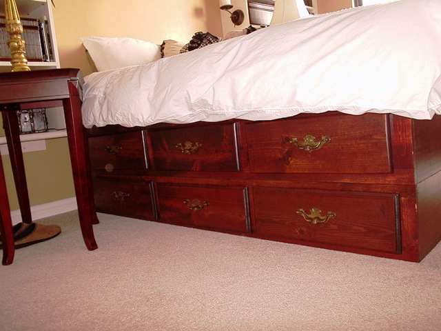The Underneath Factor. This is an old waterbed frame. The base boasts 12 drawers! Stained mahogany for beauty and varnished for longevity. An IKEA mattress fits perfectly.