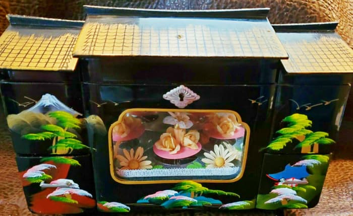This lovely made in Japan jewelry box has a beautiful dancer inside. She dances to the music played from the music box inside the cabinet. 13" wide 9.25" high 6.75" deep.