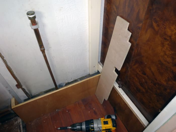 Dismantling the old wooden ducting that concealed the central heating pipes at the back of the wardrobe.